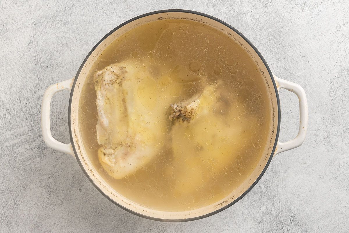 Taste of Home Chicken and Rice Soup recipe photo of the cooked chicken and broth in a dutch oven.