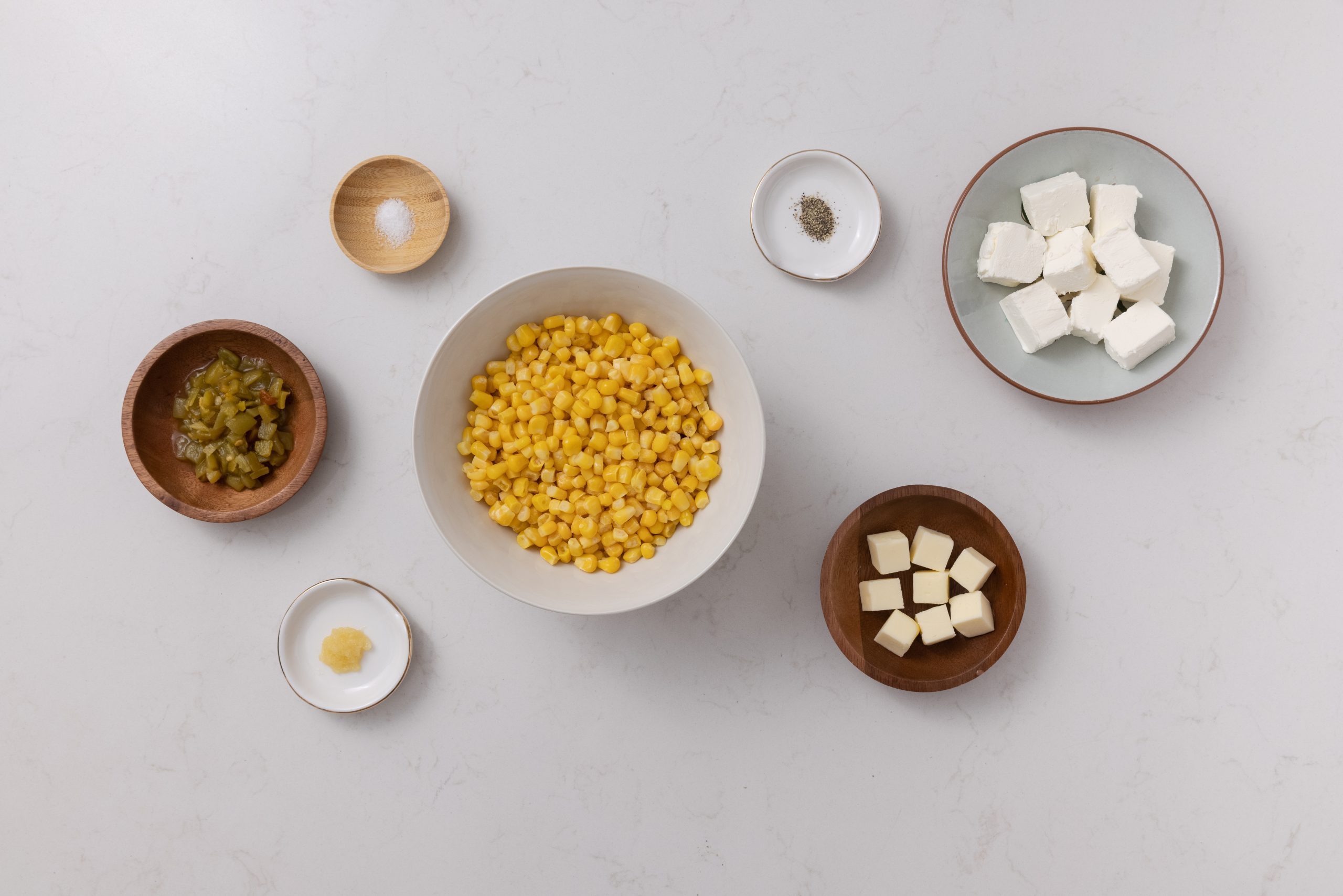 Corn casserole with cream cheese ingredients on kitchen counter.