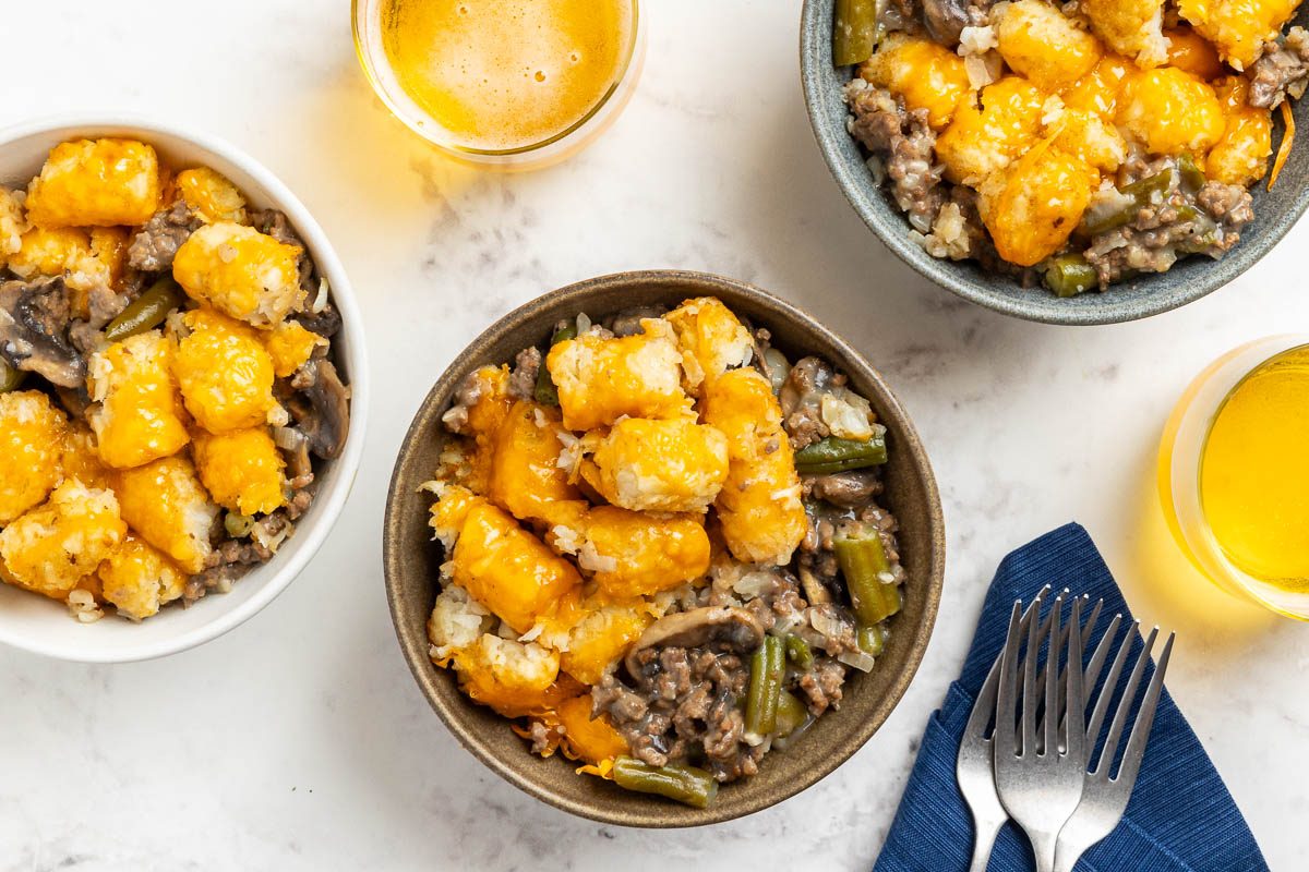 Taste of Home Crock Pot Tater Tot Casserole recipe photo of the finished recipe served into bowls with sides of beer.