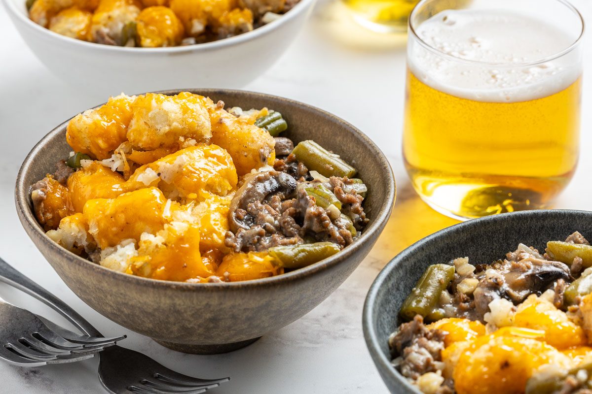 Taste of Home Crock Pot Tater Tot Casserole recipe photo of the finished recipe served into bowls with sides of beer.