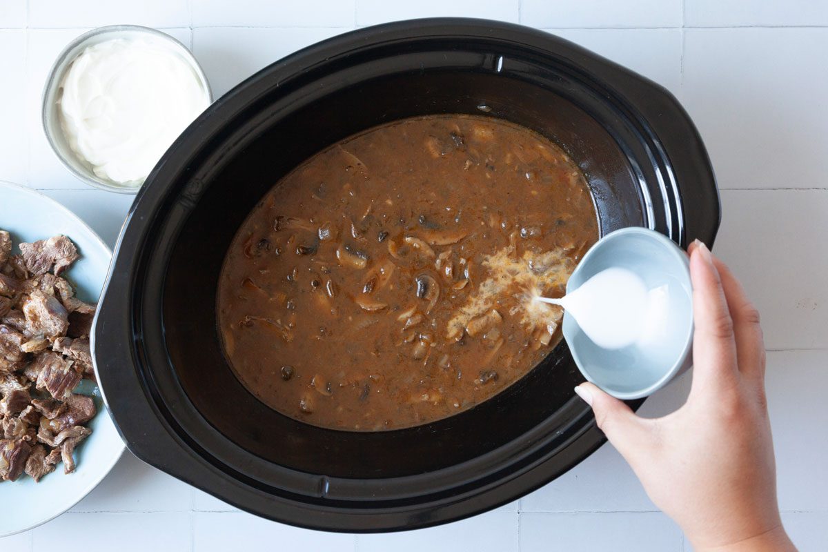 Step 2 of Taste of Home Crockpot Beef Stroganoff is to removed the meat and add the cornstarch slurry into the slow cooker. Return to cook on high for 30 minutes.
