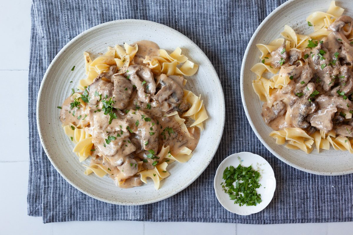 2 single servings of Taste of Home Crockpot Beef Stroganoff with egg noodles and garnished with parsley