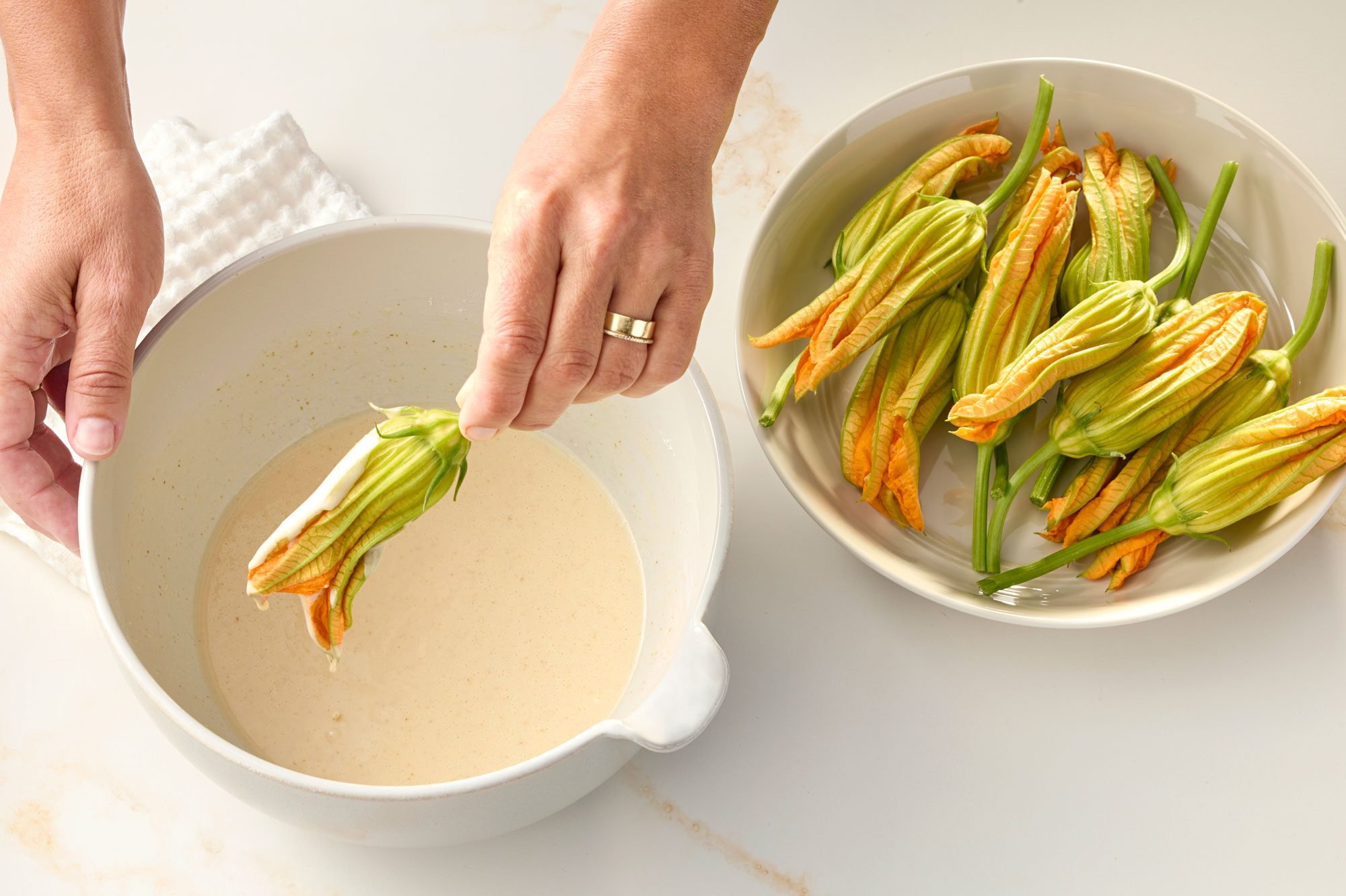 Dipping Zucchini Flower in batter; marble background