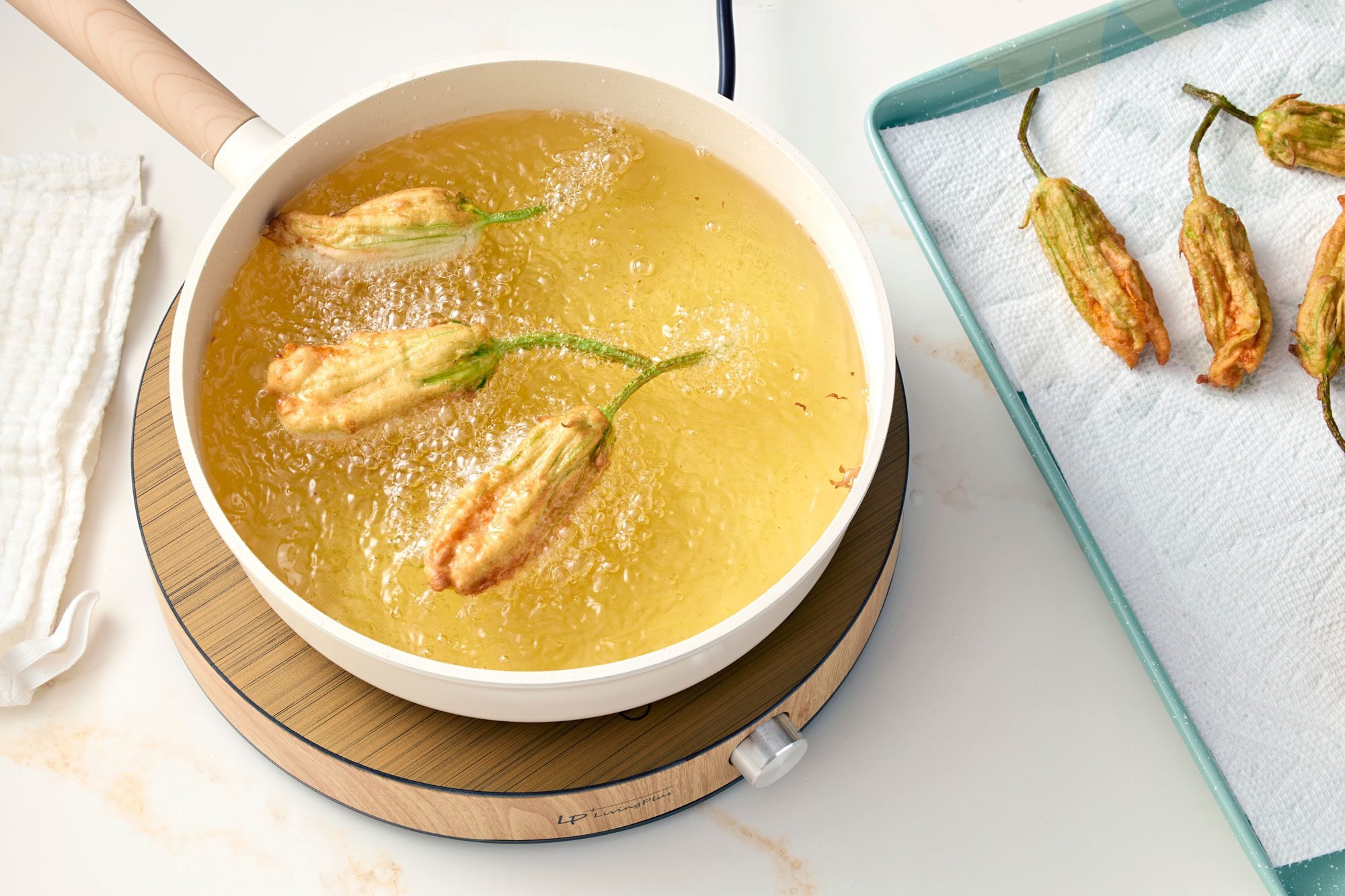 Zucchini Flowers Frying in boiling oil; marble background;