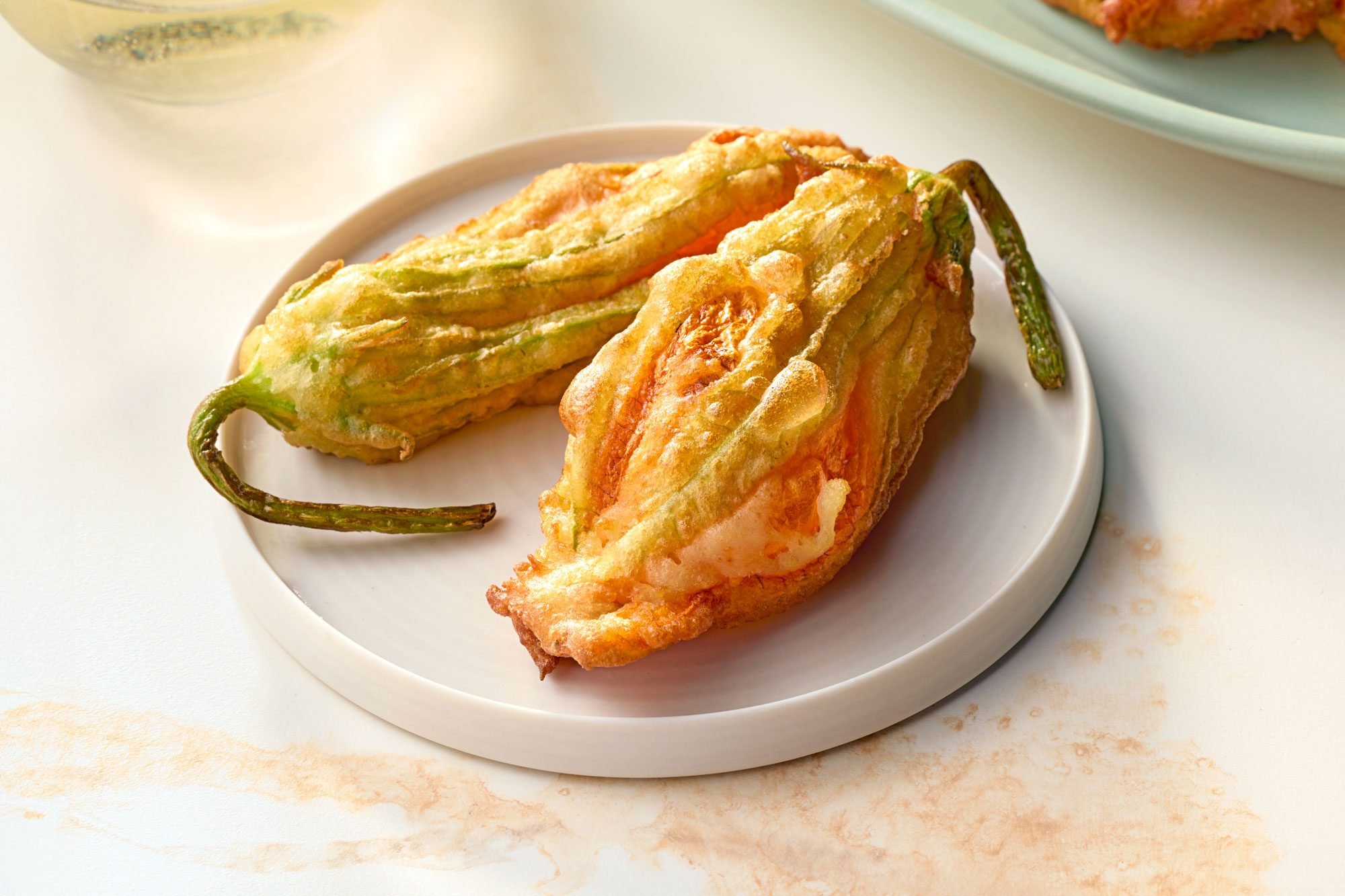 Fried Zucchini Flowers Served on a plate; marble background;