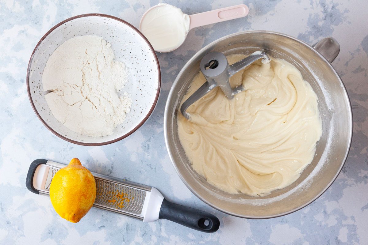 Step 1 of Taste of Home Italian Lemon Cream Cake is to beat the sugar, oil and butter on medium speed for four minutes. Add eggs, one at a time, beating well after each addition. Beat in the lemon zest and extracts. Combine the flour, baking powder, baking soda and salt; add to the creamed mixture alternately with sour cream, beating well after each addition