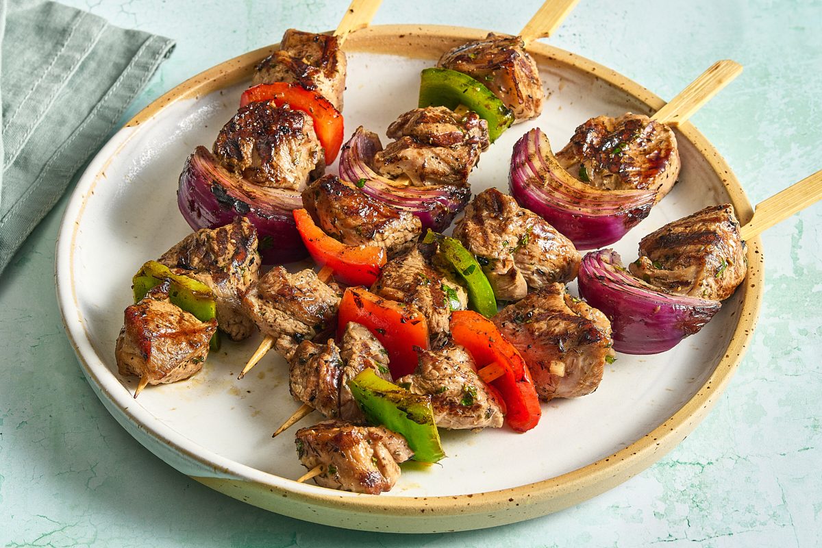 Angled shot of lamb kabobs arranged on a plate