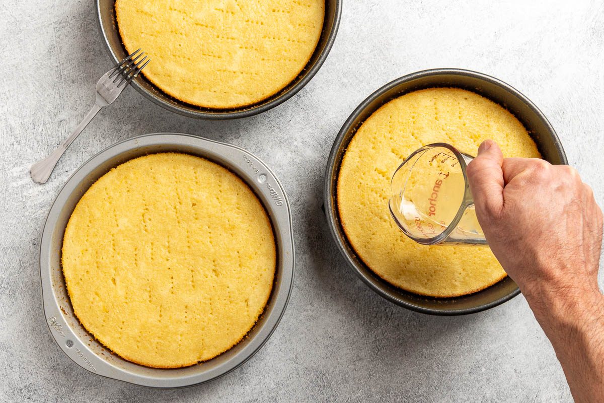 Taste of Home Lemon Raspberry Cake recipe photo of pouring the lemon syrup over the cakes.