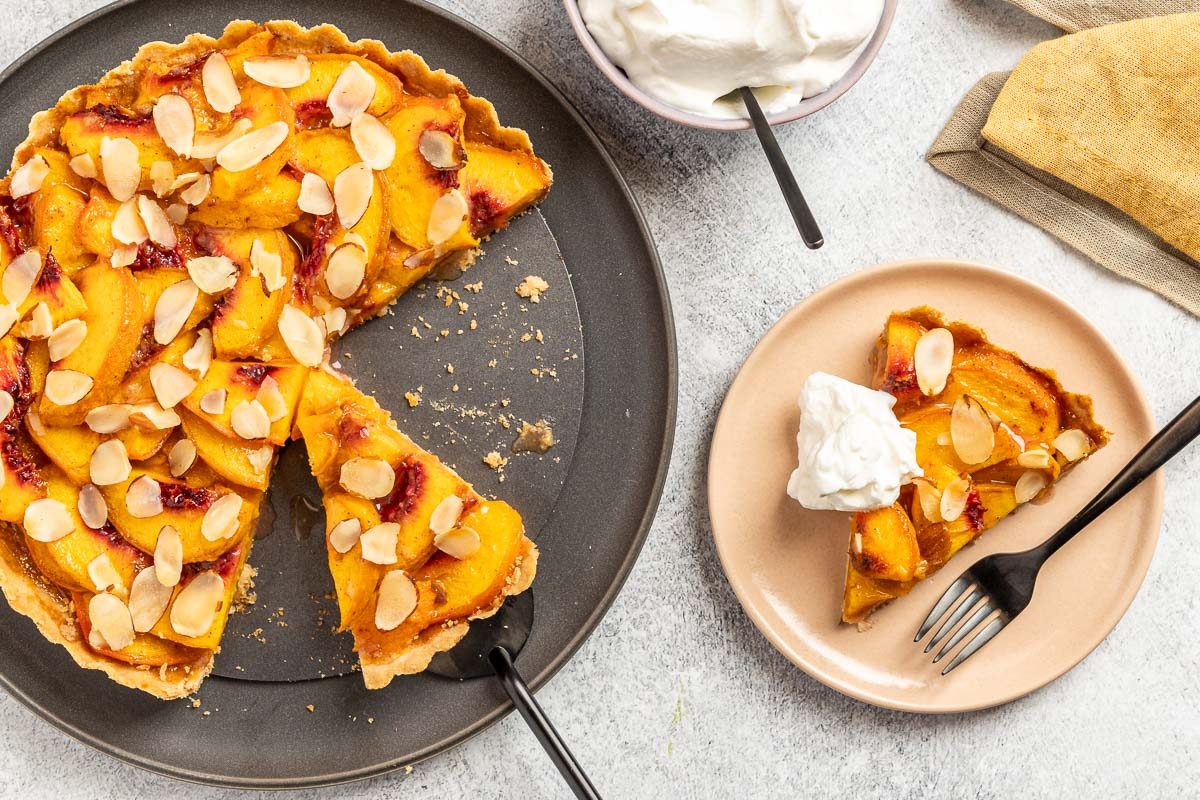 Taste of Home Peach Tart recipe photo of the peach tart cut into slices and set on plates.