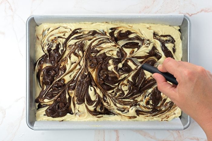 Swirling brownie batter and peanut butter cream cheese together to make peanut butter swirl brownies for Taste of Home RMS 11889