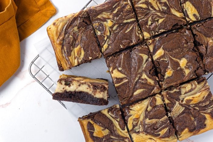 An overhead image of sliced peanut butter swirl brownies on a cooling rack with parchment paper for Taste of Home RMS 11889