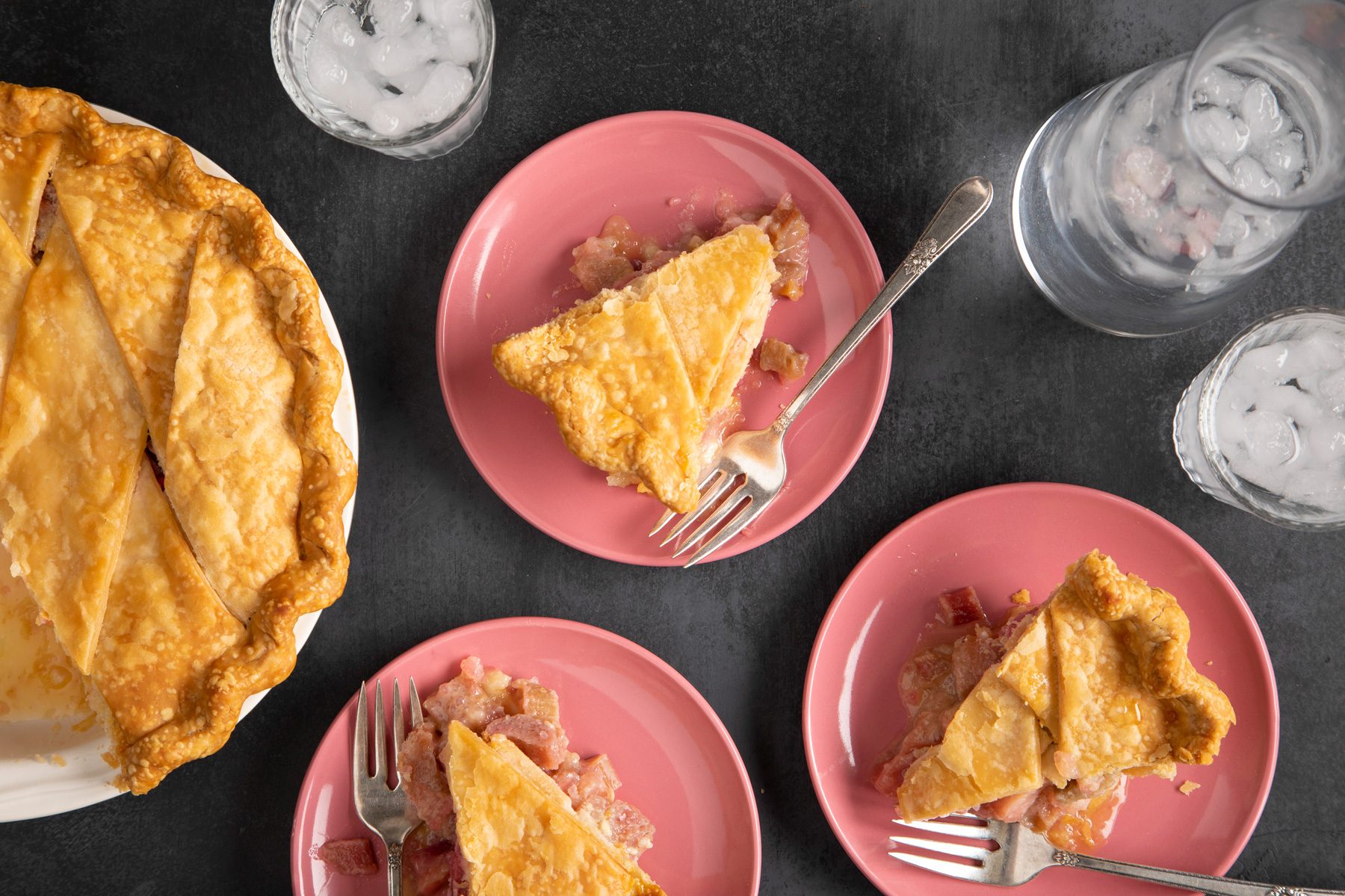 Slices of Rhubarb Custard Pie Served on pink collar plates.