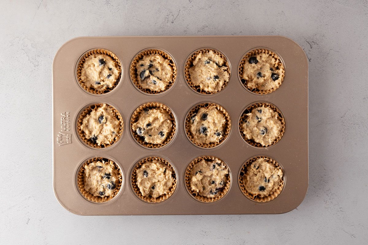 Soft Blueberry Oatmeal Muffins batter in a lined muffin tin.