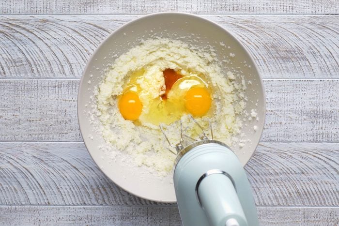 Eggs and vanilla extract are being mixed in a bowl.