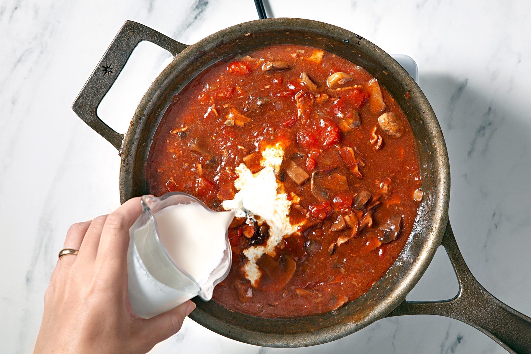 overhead shot of cream added in the skillet