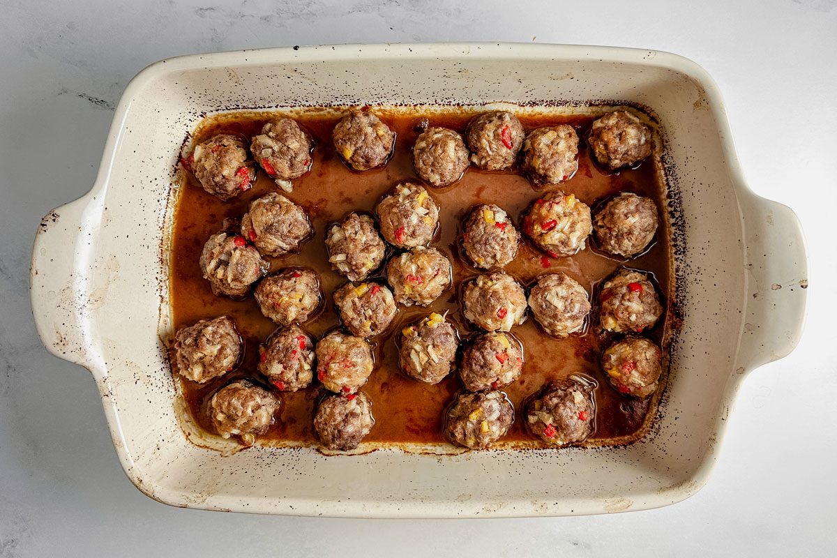 Taste of Home teriyaki meatballs in a white ceramic dish on a marble surface