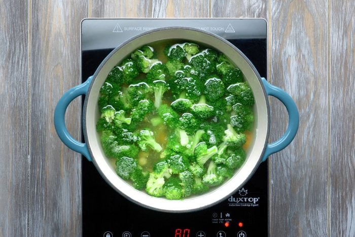Over head shot of broccoli being boiled in dutch oven
