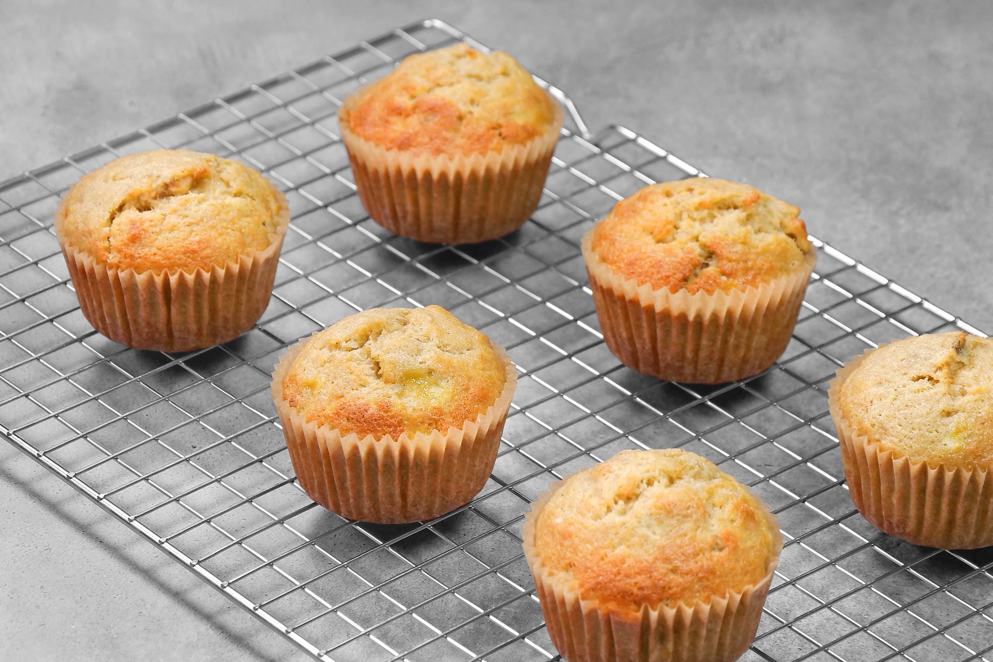 3/4th shot; grey background; Banana Nut Muffins placed over wired rack;