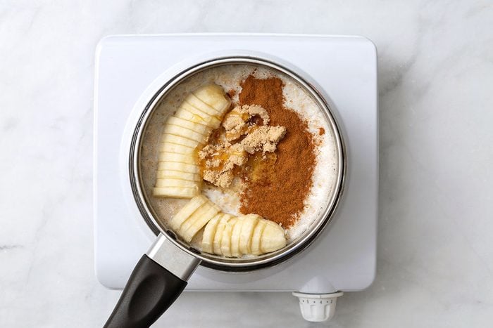 Sliced banana, brown sugar, honey and ground cinnamon mixed with cooked quick oats and milk in a small sauce pan