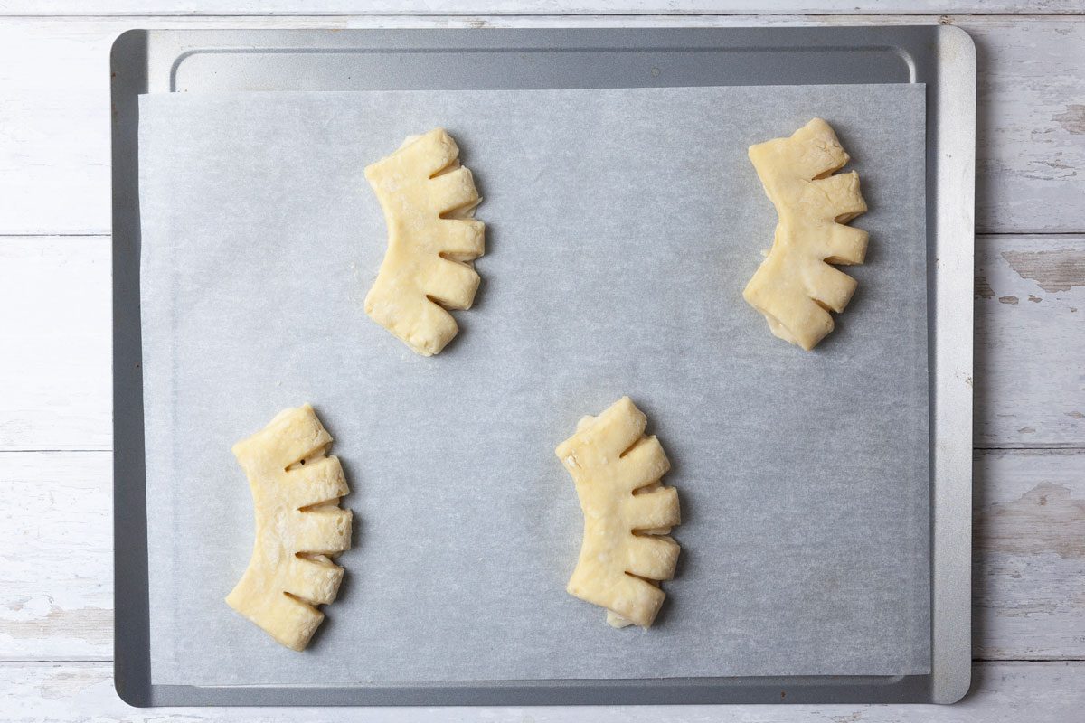 Step 5 of Taste of Home Bear Claw is to place two inches apart on parchment-lined baking sheets, seam side down. Cut each piece four times, with scissors, along a long side within 1/2 inch of edge; curve and separate the strips slightly. Repeat with the remaining dough and filling. Cover and let rise in a warm place until doubled, about one hour.