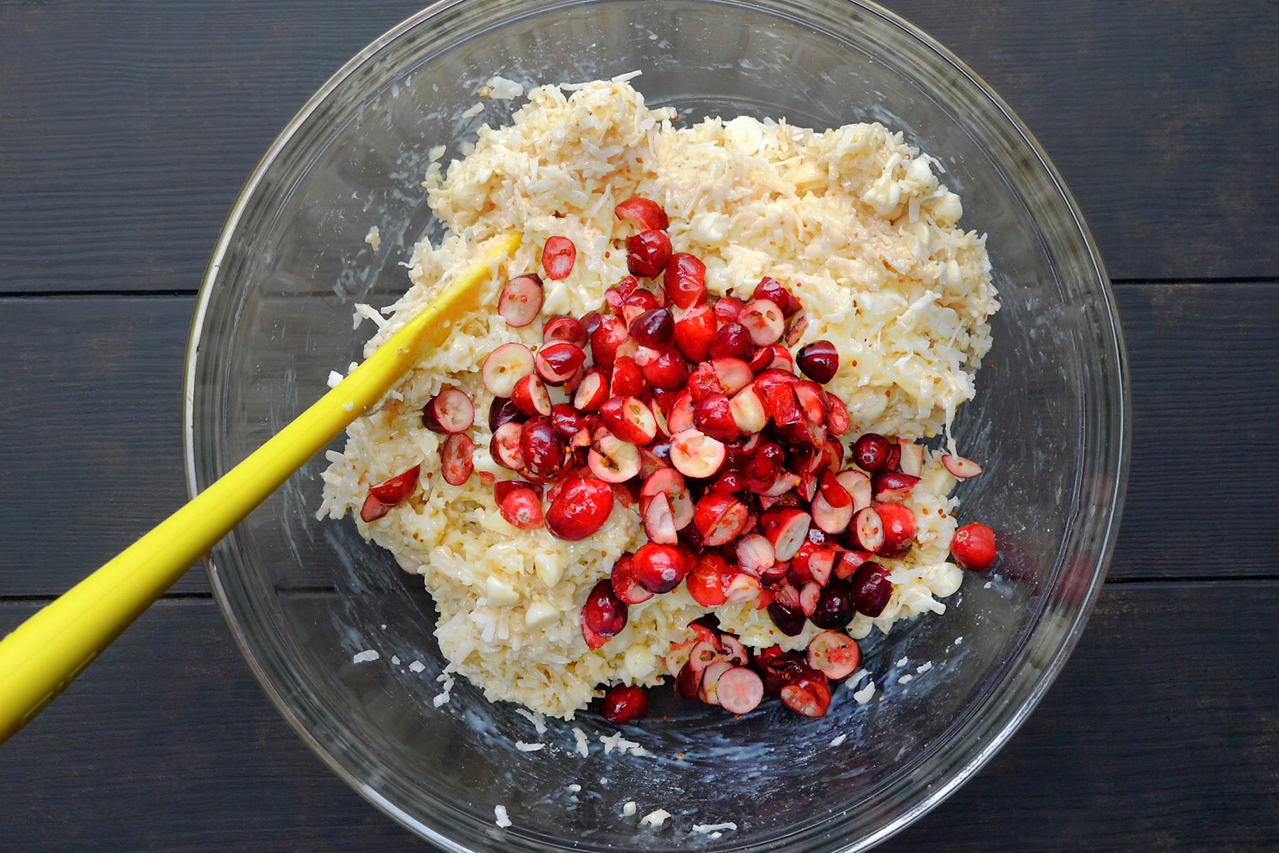 top view shot of mixing cranberries into cookie mixture