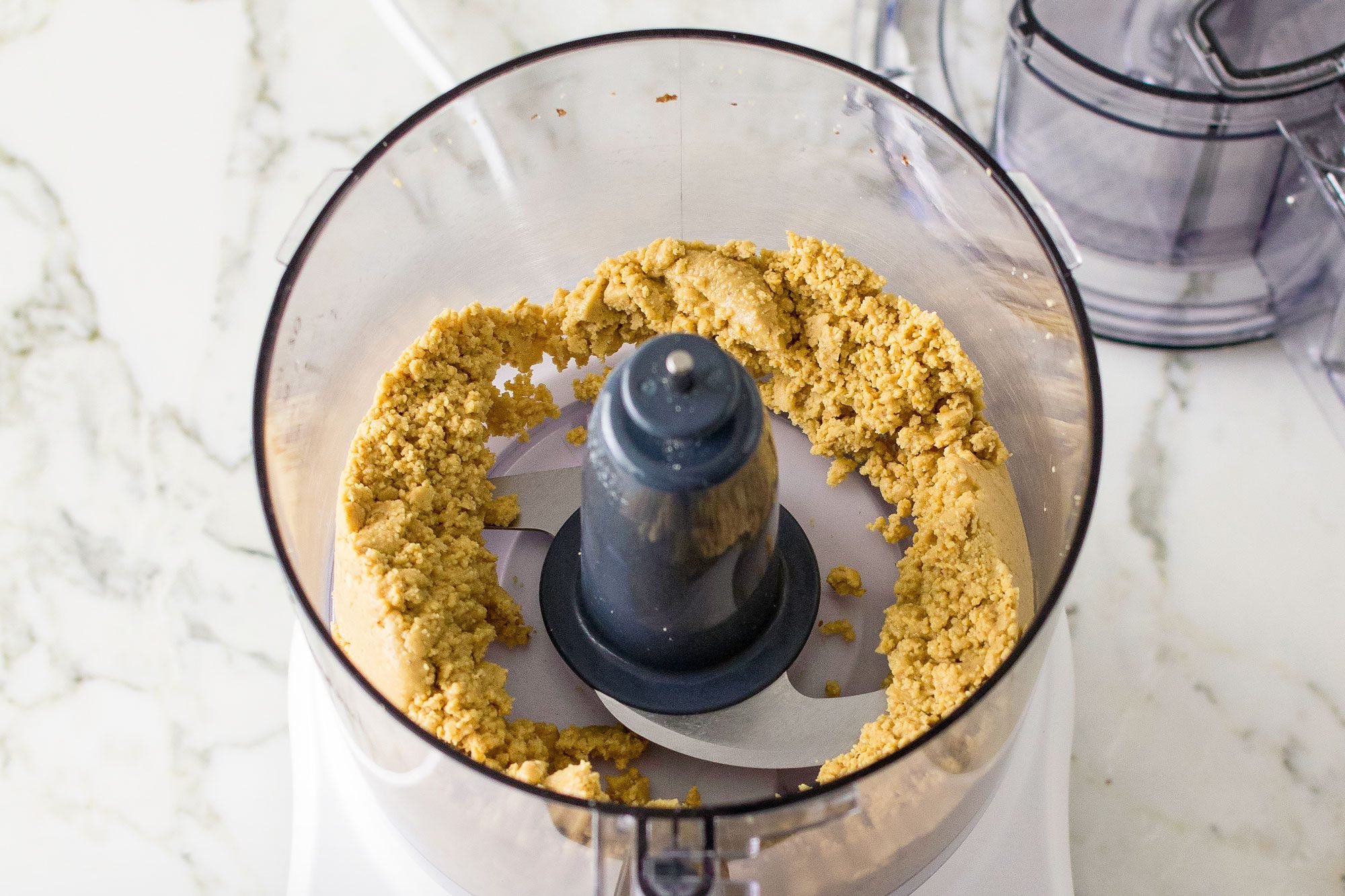 Blending Peanuts in a food processor; marble background;