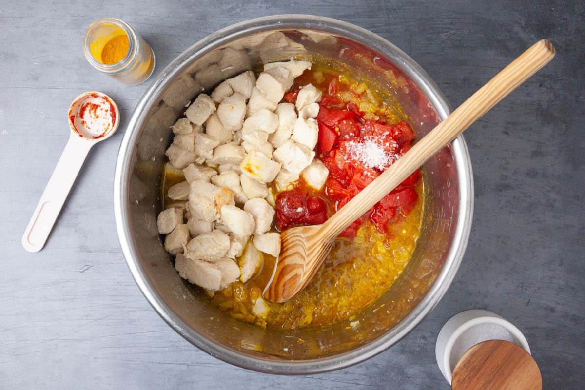 Step 2 of Taste of Home Instant Pot Chicken Curry is to Add the onion, curry, turmeric and cumin.  Cook and stir until the onion is tender, which takes three to five minutes. Next, add the broth, stirring to loosen browned bits from pan. Then, stir in the tomatoes, tomato paste, garlic, ginger, sugar, chicken and salt.