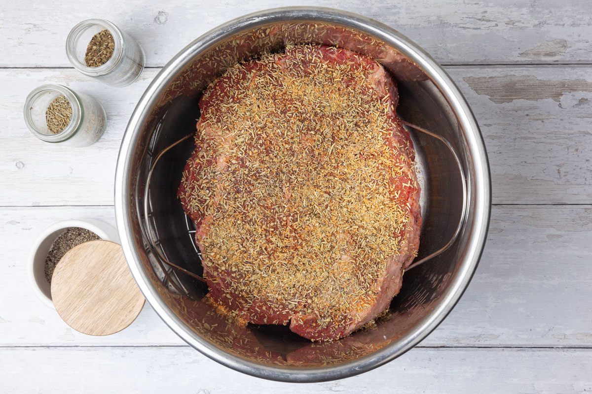 Step 1 of Taste of Home Instant Pot French Dip is to place the boneless beef chuck roast on a trivet in a 6-quart electric pressure cooker or Instant Pot. Sprinkle the roast with dried oregano, dried rosemary, seasoned salt and pepper.