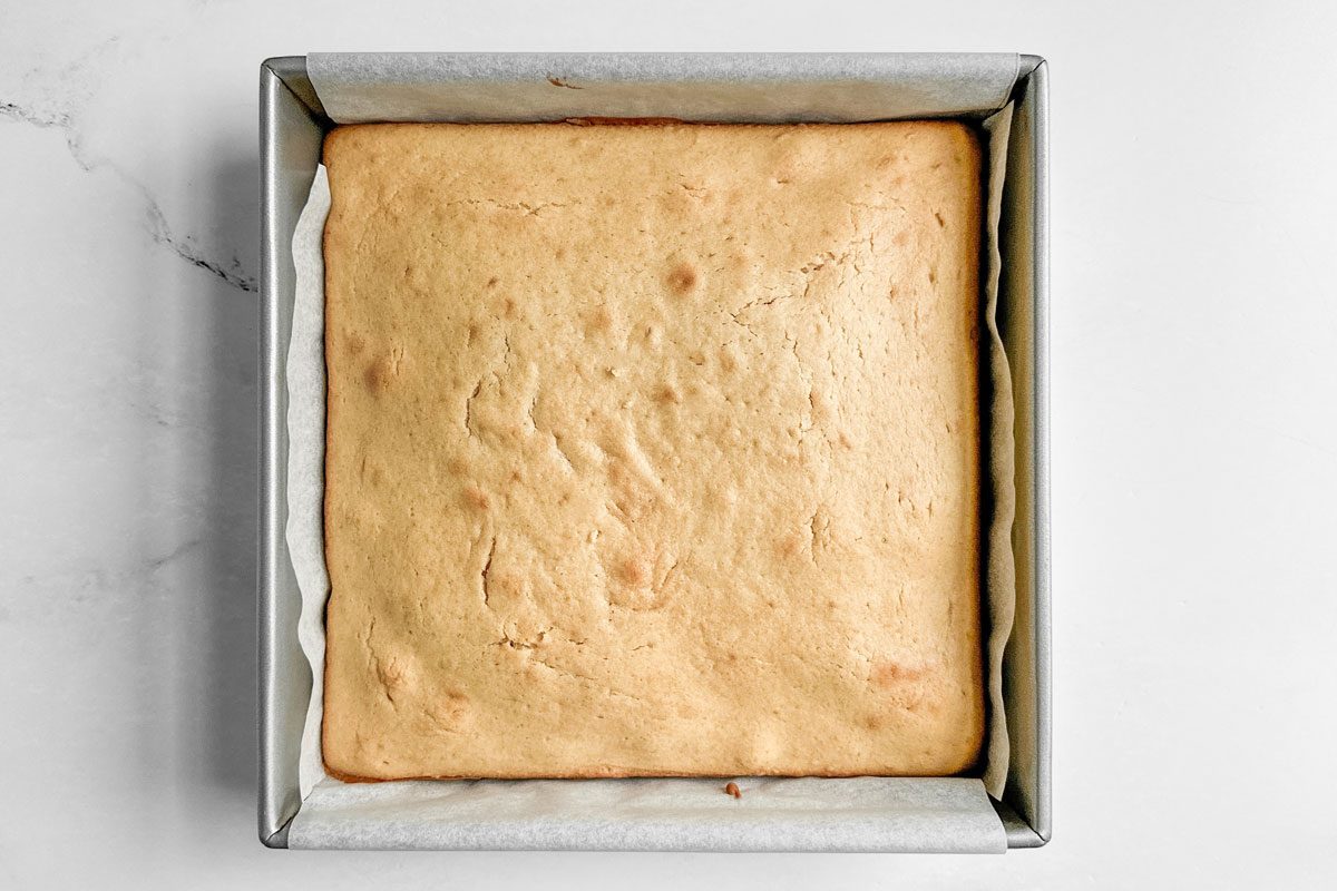 Taste of Home Peanut Butter Cake in a metal baking pan on a marble surface