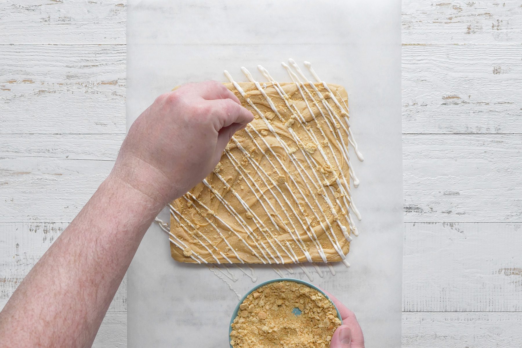 Overhead shot of sprinkled with graham cracker crumbs; butter paper; white wooden background;