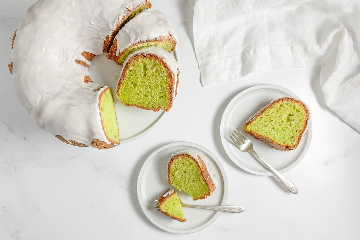 Taste of Home Pistachio Bundt Cake on white plates on a marble surface