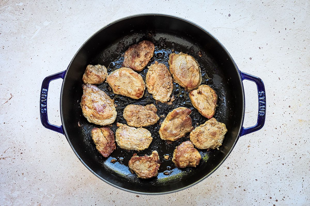 Pork and potatoes preparation: seared pork tenderloin in a skillet.
