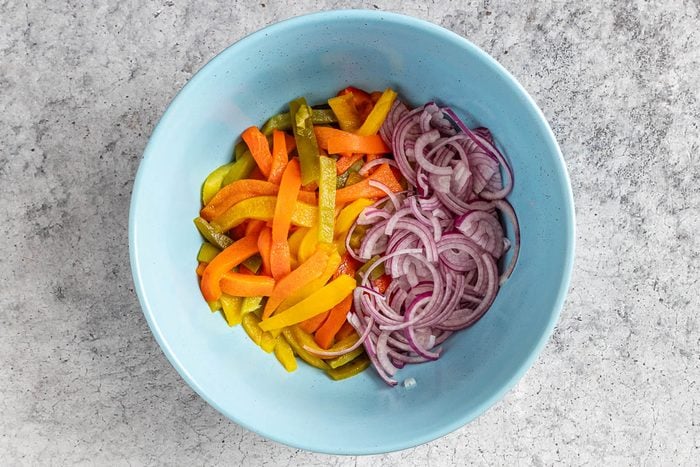 Taste of Home Roasted Pepper Salad photo of the roasted peppers and onion in a mixing bowl.