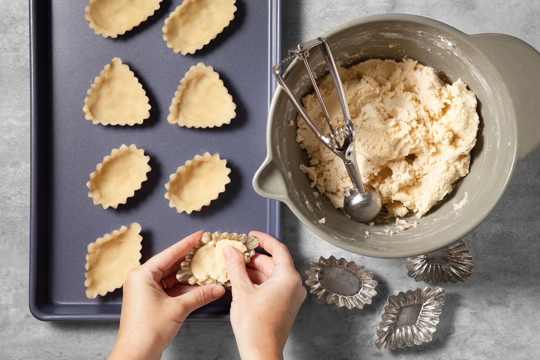 Using ungreased sandbakkelse molds, press dough into each mold.