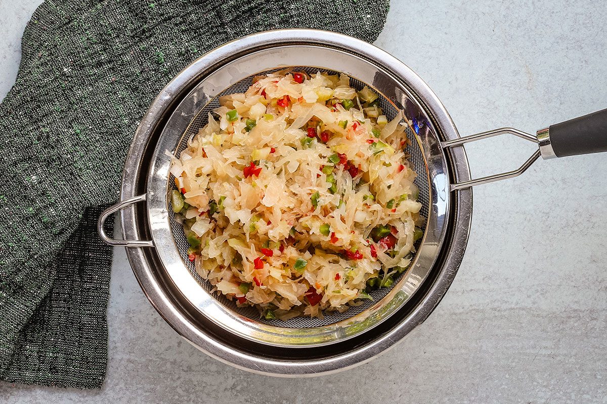 Draining chilled sauerkraut salad.