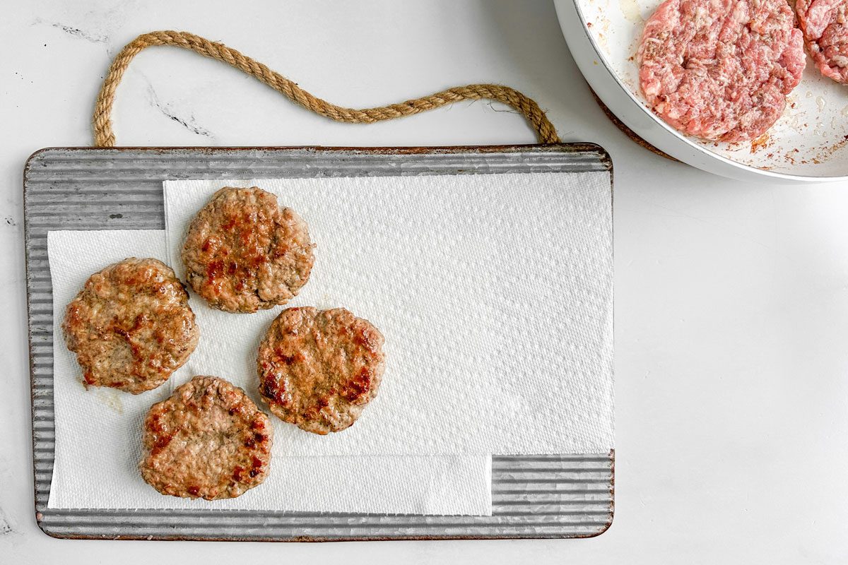 Taste of Home Sausage Patties on a paper towel lined metal tray on a marble surface