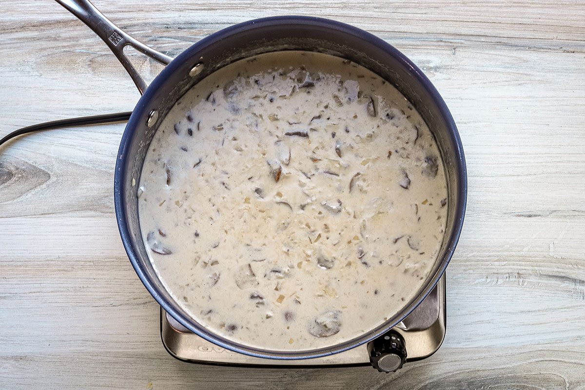Wine and cream are added to the mushrooms and onions for a spinach risotto.