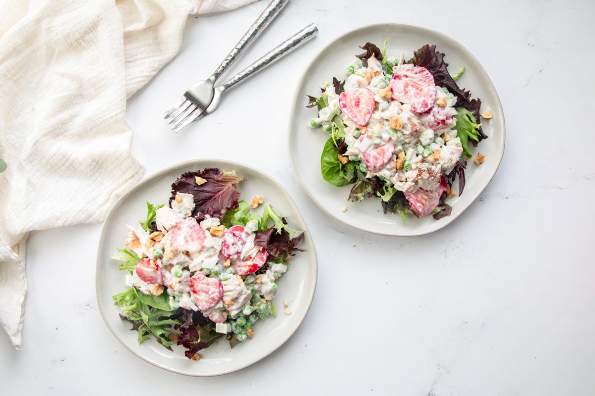 Overhead beauty shot for Taste of Home Tarragon Chicken Salad on a marble surface with forks and linen.