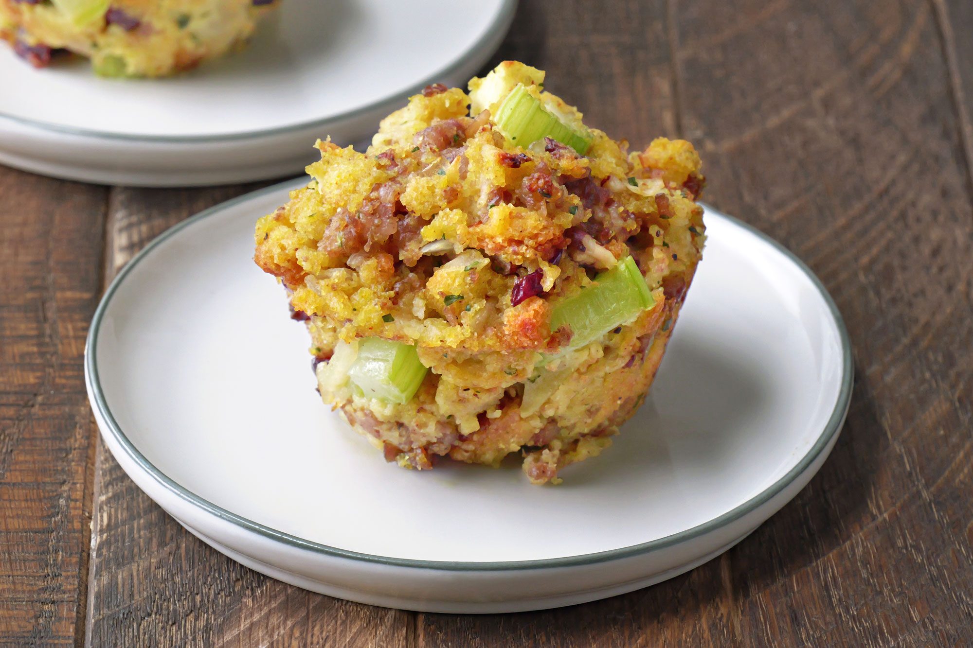 close shot of sausage stuffing muffin in a small plate; Wooden Background;