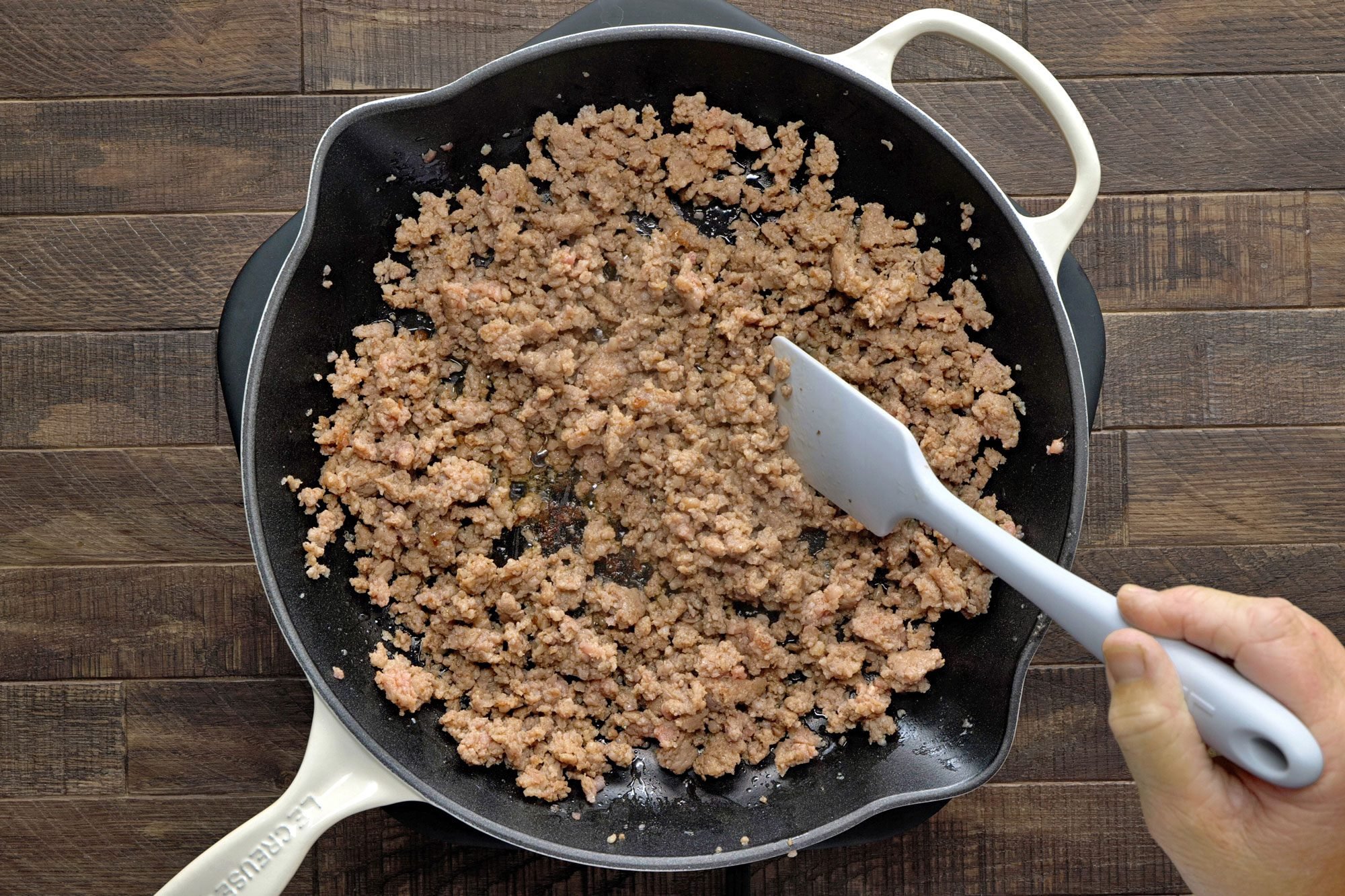 In a large skillet, cook sausage over medium heat until no longer pink; Wooden Background;