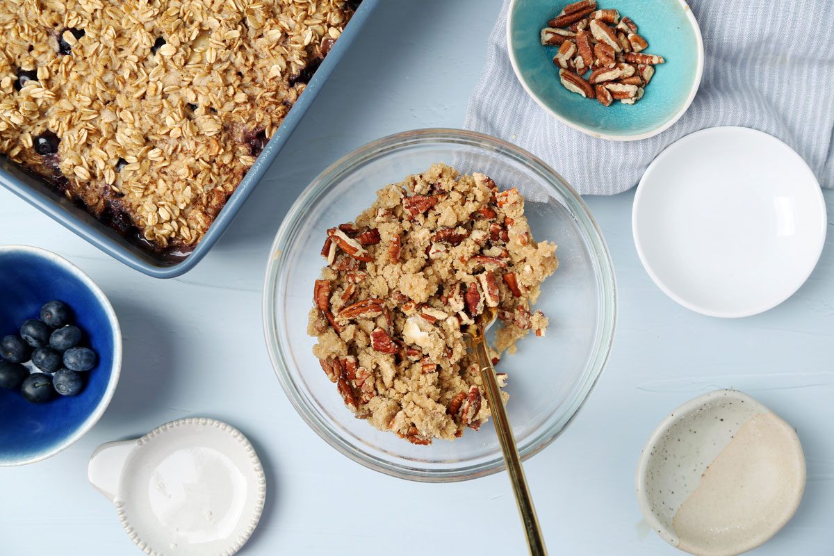 Process of making Taste of Home's Blueberry Baked Oatmeal in small dishes on a light blue surface.