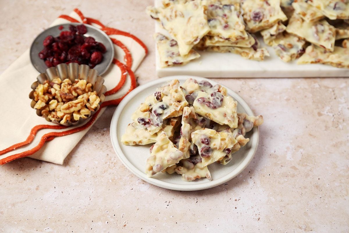 Close up of Taste of Home's White Chocolate Bark served on a white plate on a beige countertop.