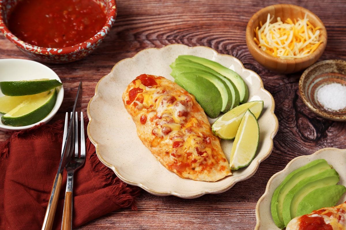 Close up of Taste of Home's Salsa Chicken served on a light brown plate on a wooden surface.