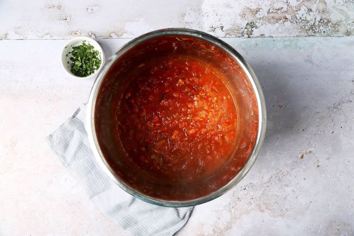 Cooking Taste of Home's Red Clam Sauce in a slow cooker on a grey background.