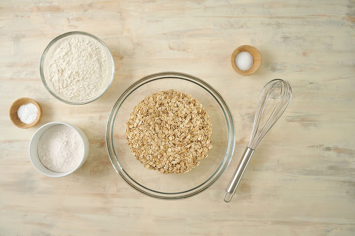 Overhead view of oats, flour, instant pudding mix, baking soda, and salt in a separate bowl for the Taste of Home Air Fryer Oatmeal Cookies recipe.