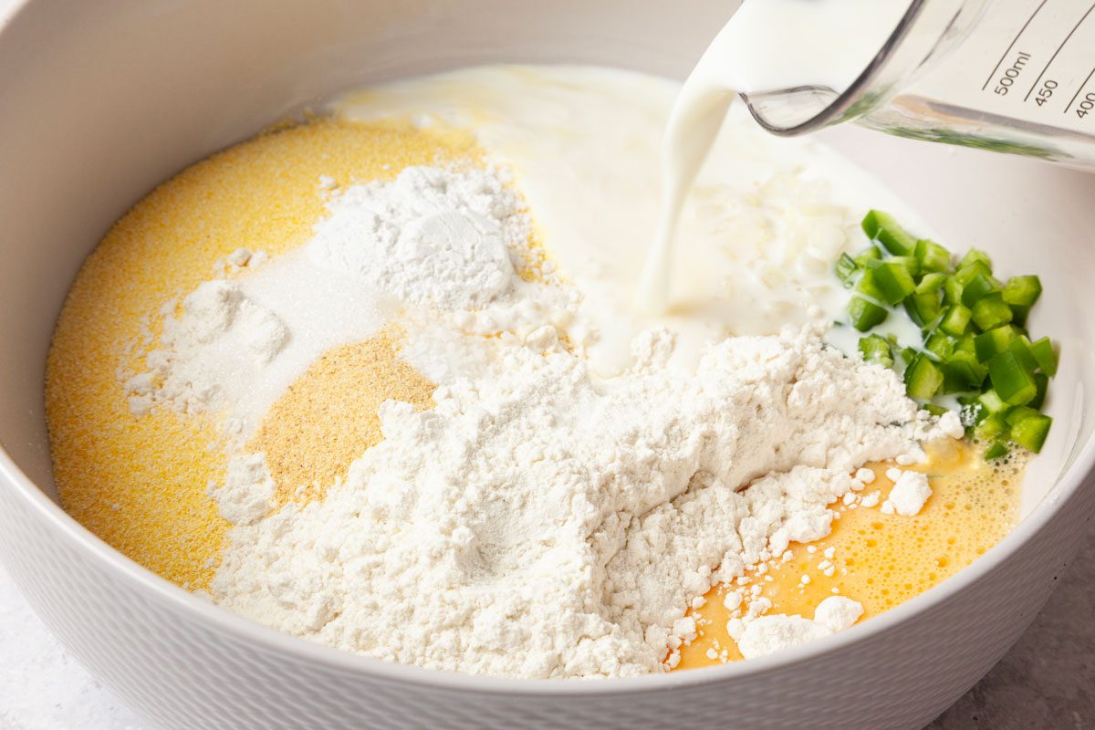 Step 1 of Taste of Home Air-Fryer Hush Puppies is to whisk together the cornmeal, flour, baking powder, sugar, salt and garlic powder. Whisk in the buttermilk, egg, chopped onion and diced jalapeno. Let the batter sit for 5 to 10 minutes.