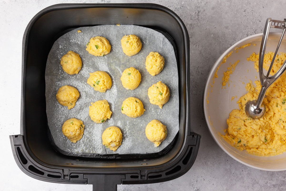 Step 2 of Taste of Home Air-Fryer Hush Puppies is to Preheat the air fryer to 350°F. In batches, scoop the dough by tablespoonfuls onto greased parchment in an air-fryer basket. Spritz with cooking spray. Bake for five to six minutes or until golden brown.