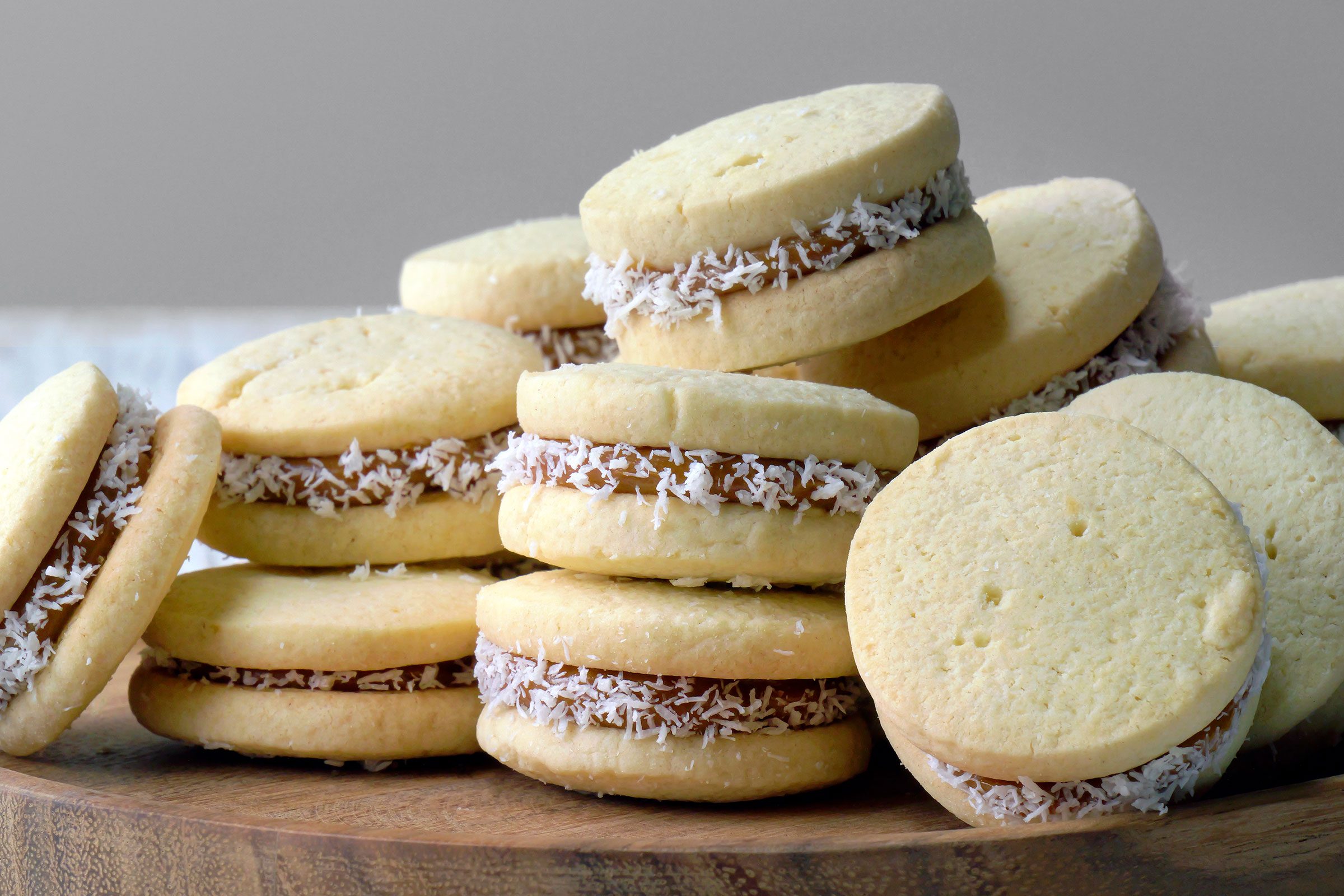 Alfajores cookies on a table top in a wooden tray