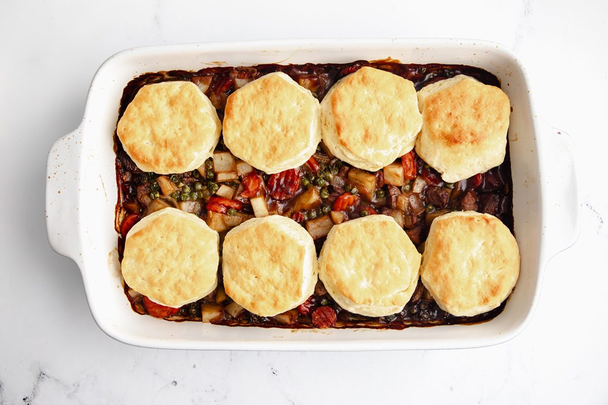 Overhead shot for Taste of Home Beef Potpie with Biscuits, ingredients in a baking dish with cooked biscuits on top.