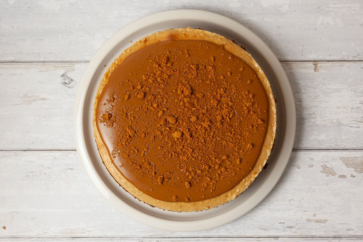 Step 5 of Taste of Home Biscoff Cheesecake is top with cookie sprad and crumbs